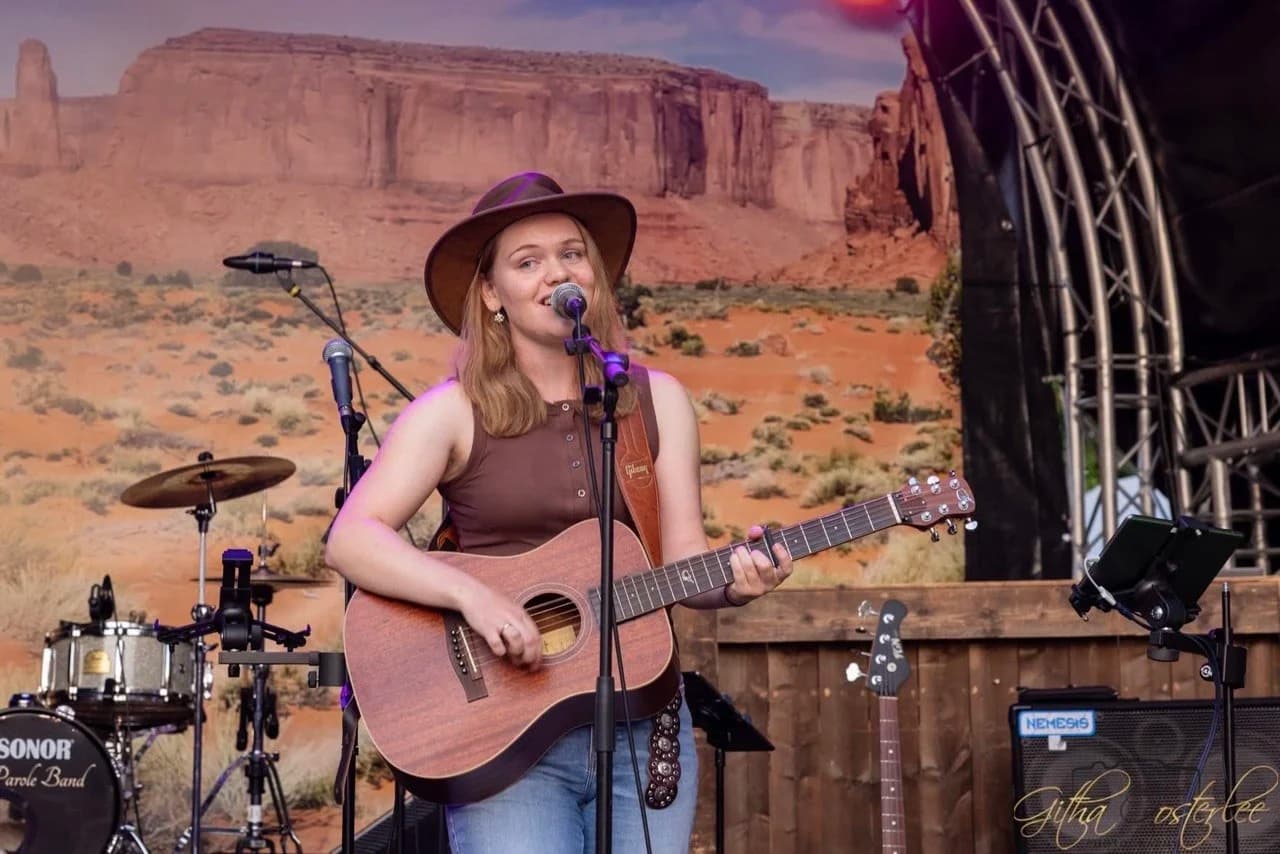 Cécile Gardens performing live with her guitar.
