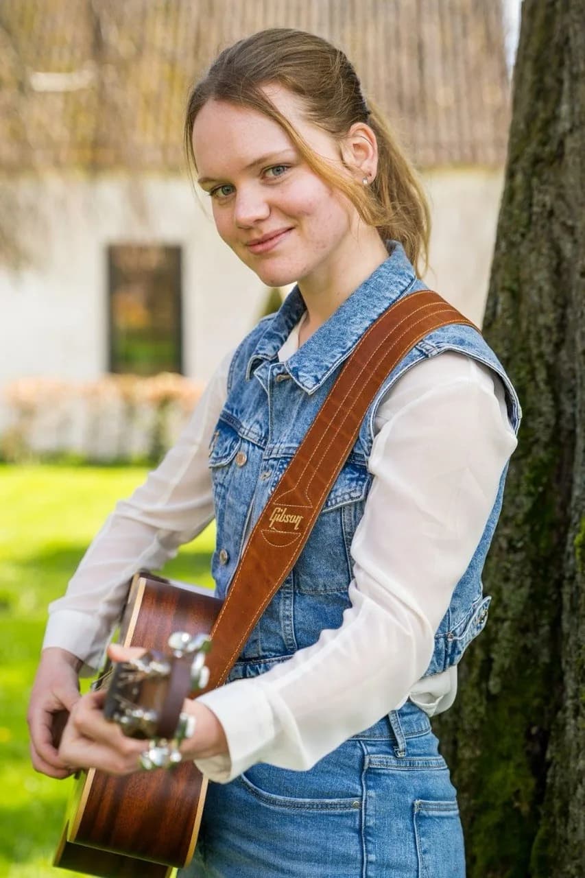 Cécile Gardens with her guitar at a live show.