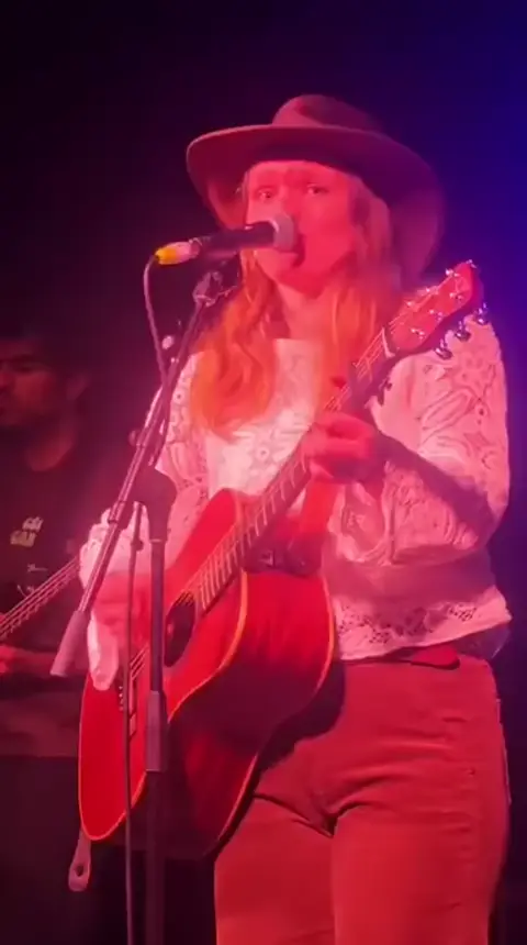 Cécile Gardens performing an original song.